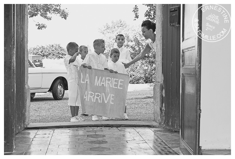 les enfants portent un panneau annonçant que La mariée arrive, mariage en Camargue, reportage photo de mariage par Ernestine et sa famille