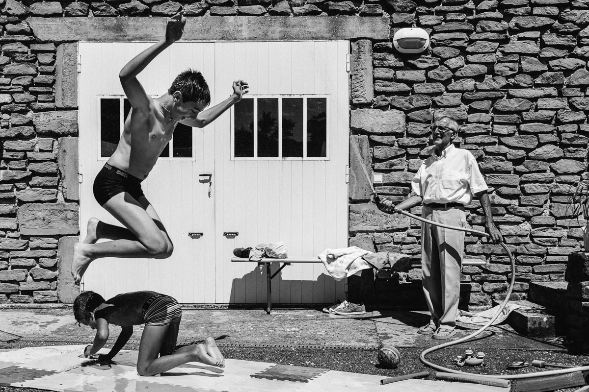 Ernestine-et-sa-famille-wedding and life photographer_MG-41 ‣ Photographe de famille à l'approche documentaire pour vos évènements ou votre vie quotidienne, à Paris et dans toute la France jeux d'eau entre cousisns pendant reportage documentaire de famille et baptême