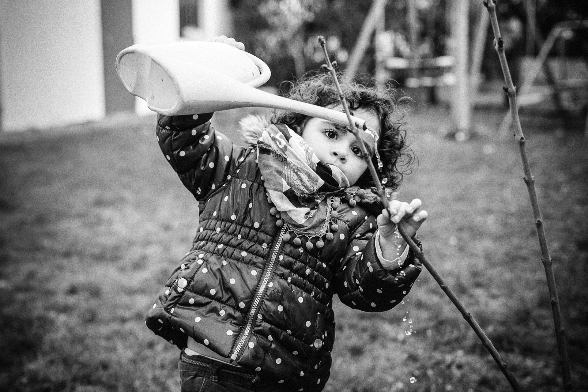 petite fille qui arrose les bouton de fleur - reportage photo du quotidien dans une famille à Troyes (aube)