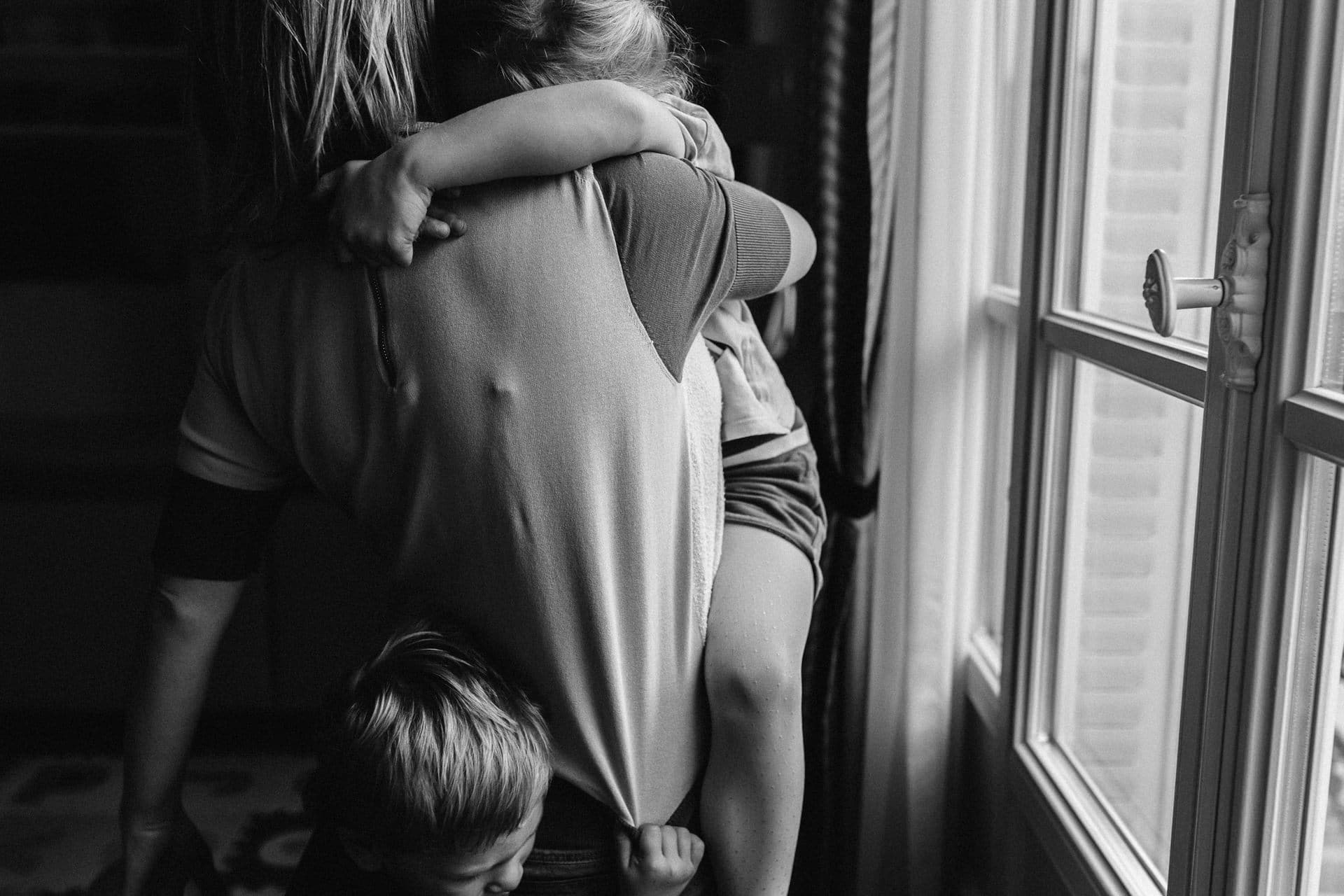 Ernestine et sa famille - wedding and life photographer - 1920-366 ‣ Photographe de famille à l'approche documentaire pour vos évènements ou votre vie quotidienne, à Paris et dans toute la France maman et ses enfants de dos devant une fenêtre - reportage du quotidien par Marine Poron photographe de famille à Paris