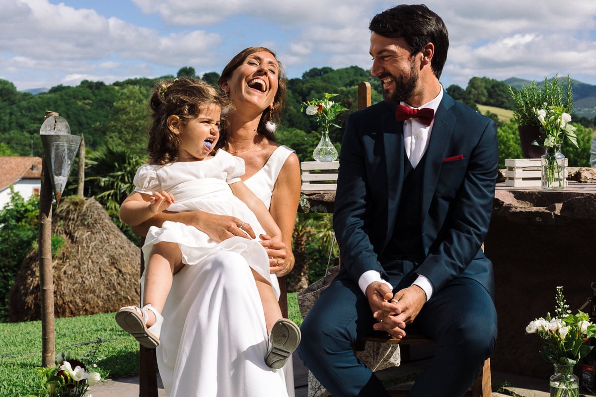 Mariage sur deux jours au Pays Basque - cérémonie laïque au gite au milieu des fougères - fille des mariés qui tire une langue bleue