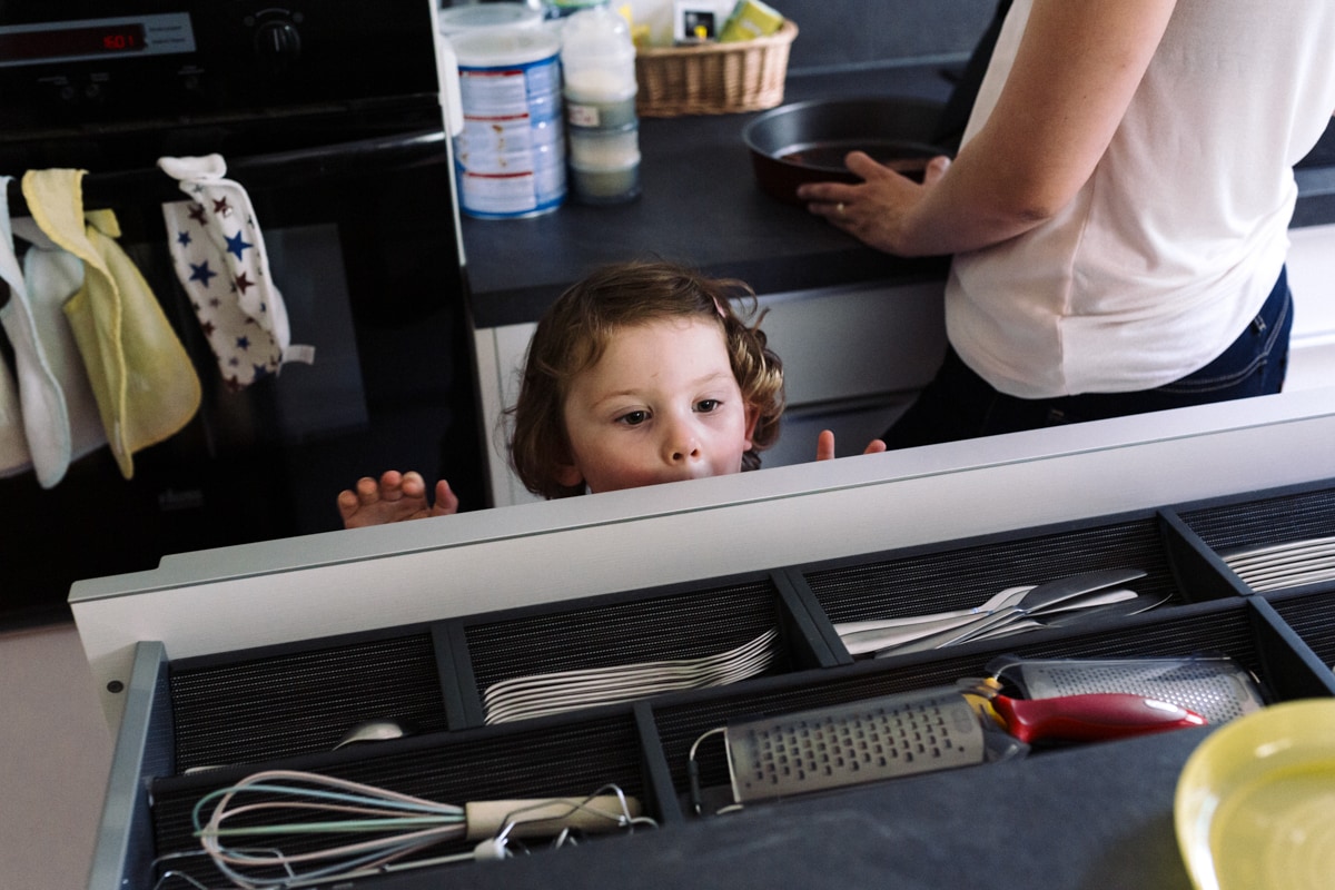 reportage à la maison photo de famille à Rueil Malmaison (92) petit fille curieuse dans la cuisine