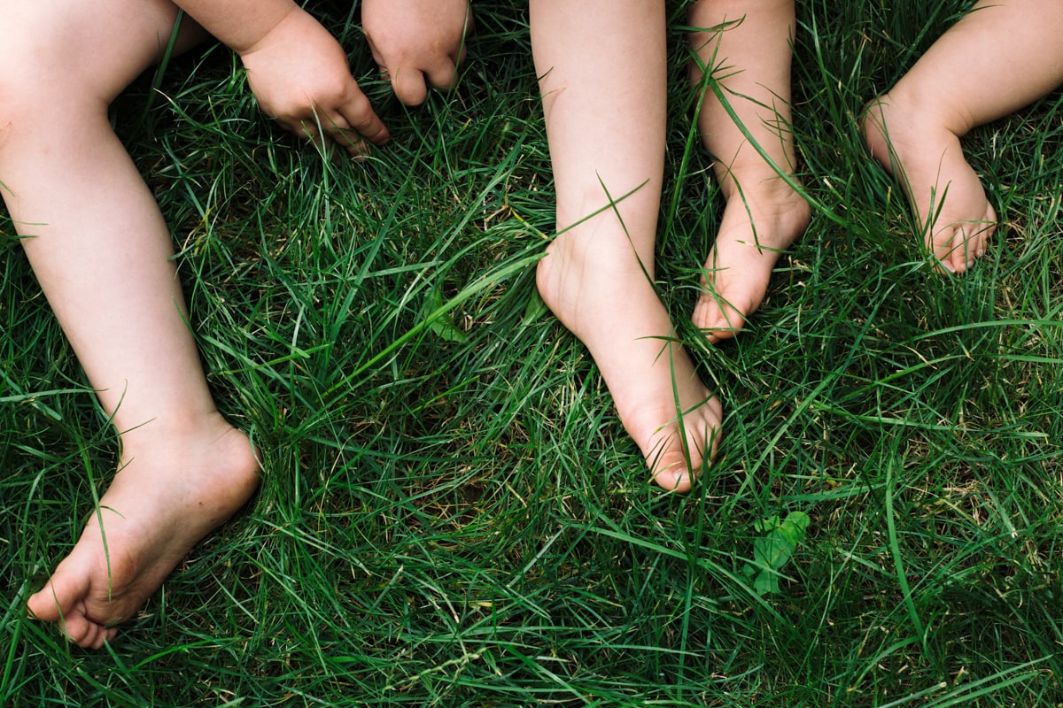 reportage à la maison photo de famille à Rueil Malmaison (92) pieds et mains dans l'herbe
