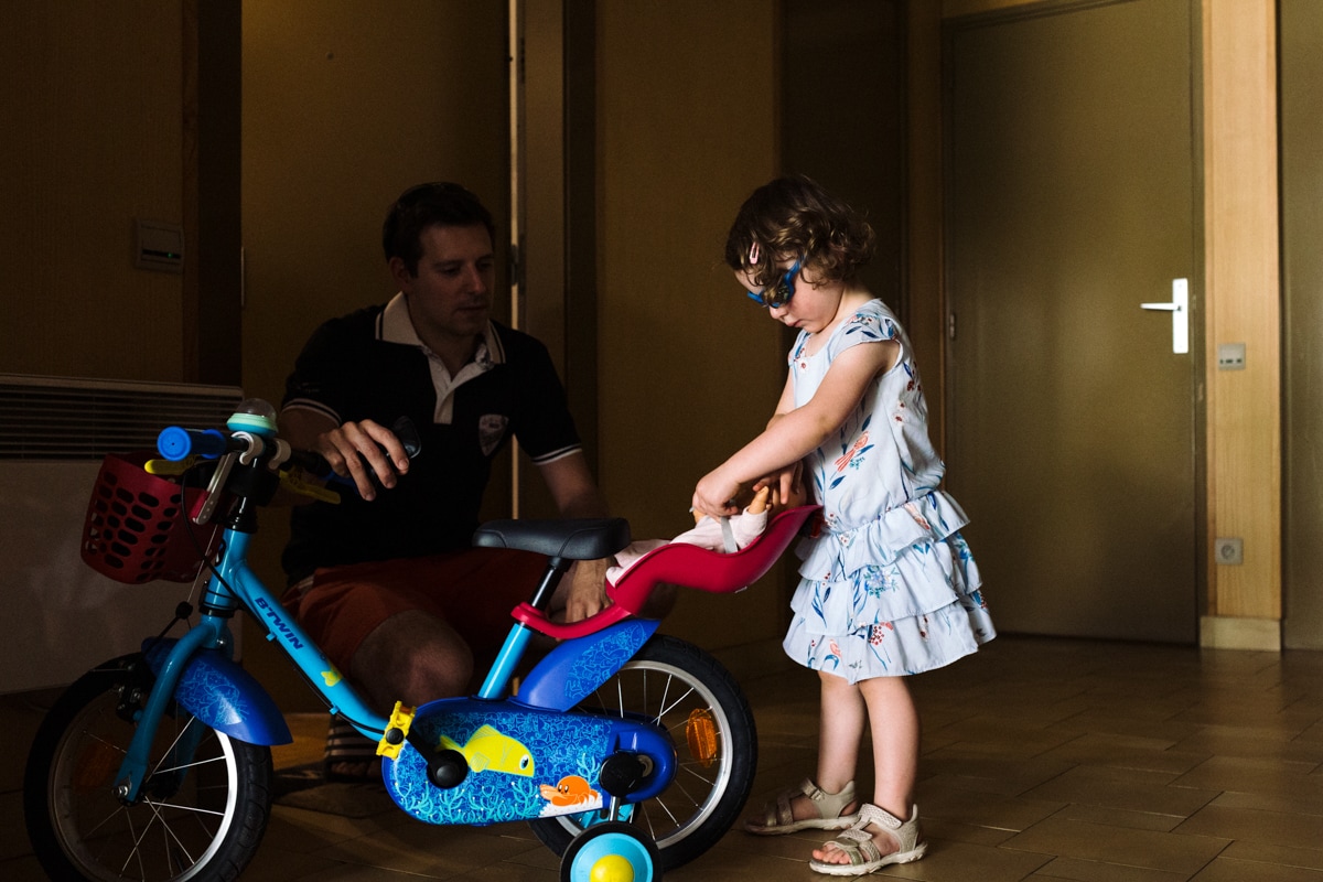reportage à la maison photo de famille à Rueil Malmaison (92) préparation du vélo avec papa