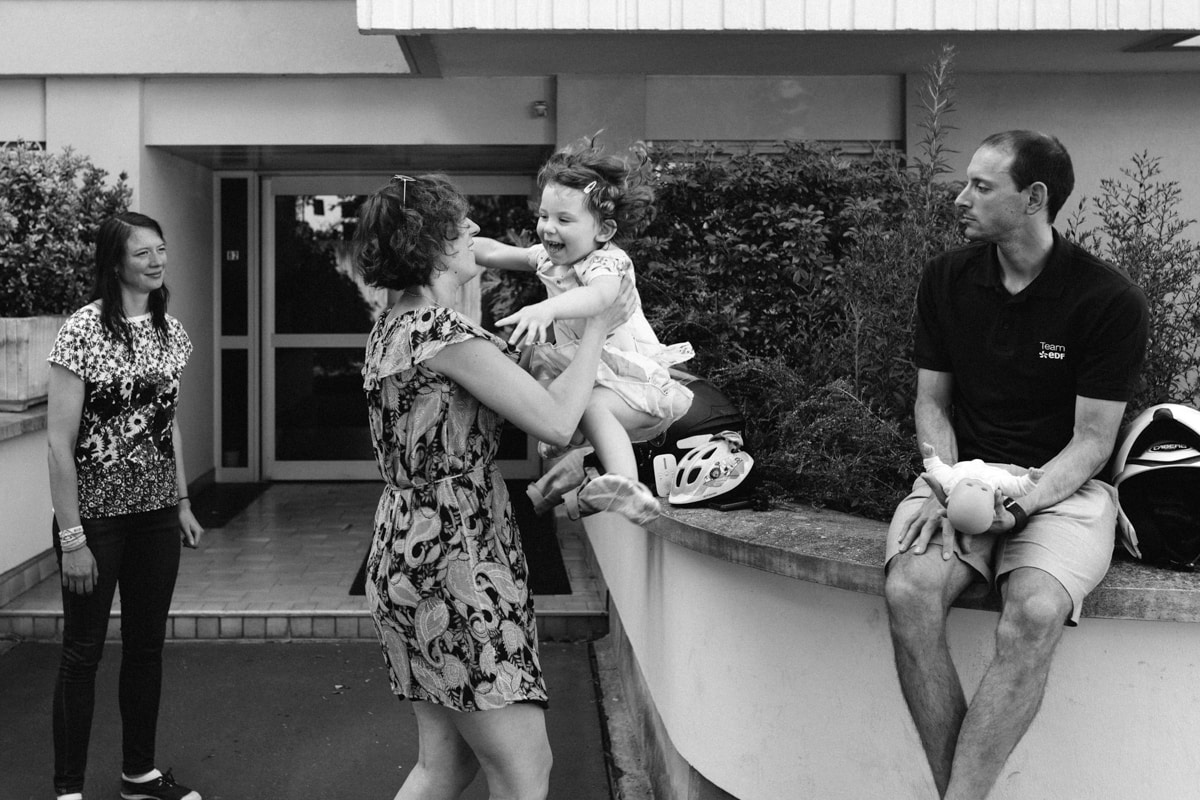 reportage à la maison photo de famille à Rueil Malmaison (92) sauter dans les bras de maman devant tata et tonton