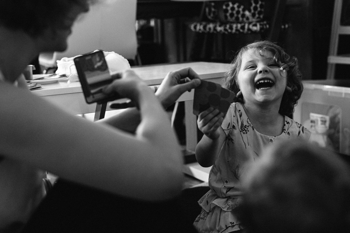 reportage à la maison photo de famille à Rueil Malmaison (92) rire en jouant aux cartes