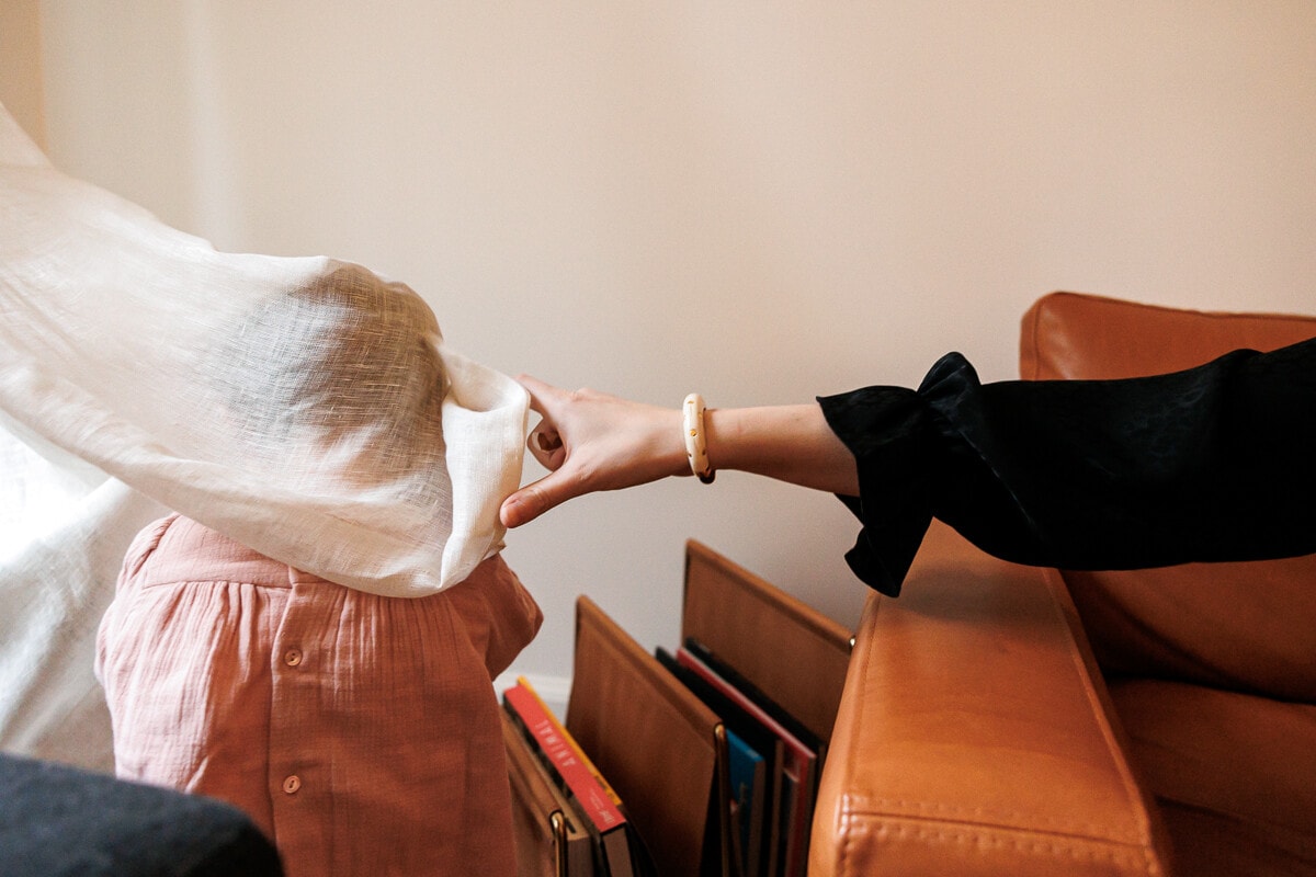 Ernestine-et-sa-famille-wedding and life photographer_-59 ‣ Photographe de famille à l'approche documentaire pour vos évènements ou votre vie quotidienne, à Paris et dans toute la France Petite fille cachée sous le rideaux chatouillée par sa maman. reportage de famille à Paris 17eme.