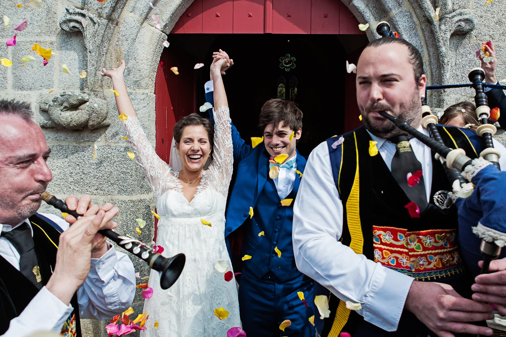 Ernestine-et-sa-famille-wedding and life photographer_2014-0004 ‣ Photographe de famille à l'approche documentaire pour vos évènements ou votre vie quotidienne, à Paris et dans toute la France Sortie de l'église sous les confettis avec des sonneurs au premier plan à l'église de Benodet par Ernestine et sa famille photographe de mariage à l'approche reportage