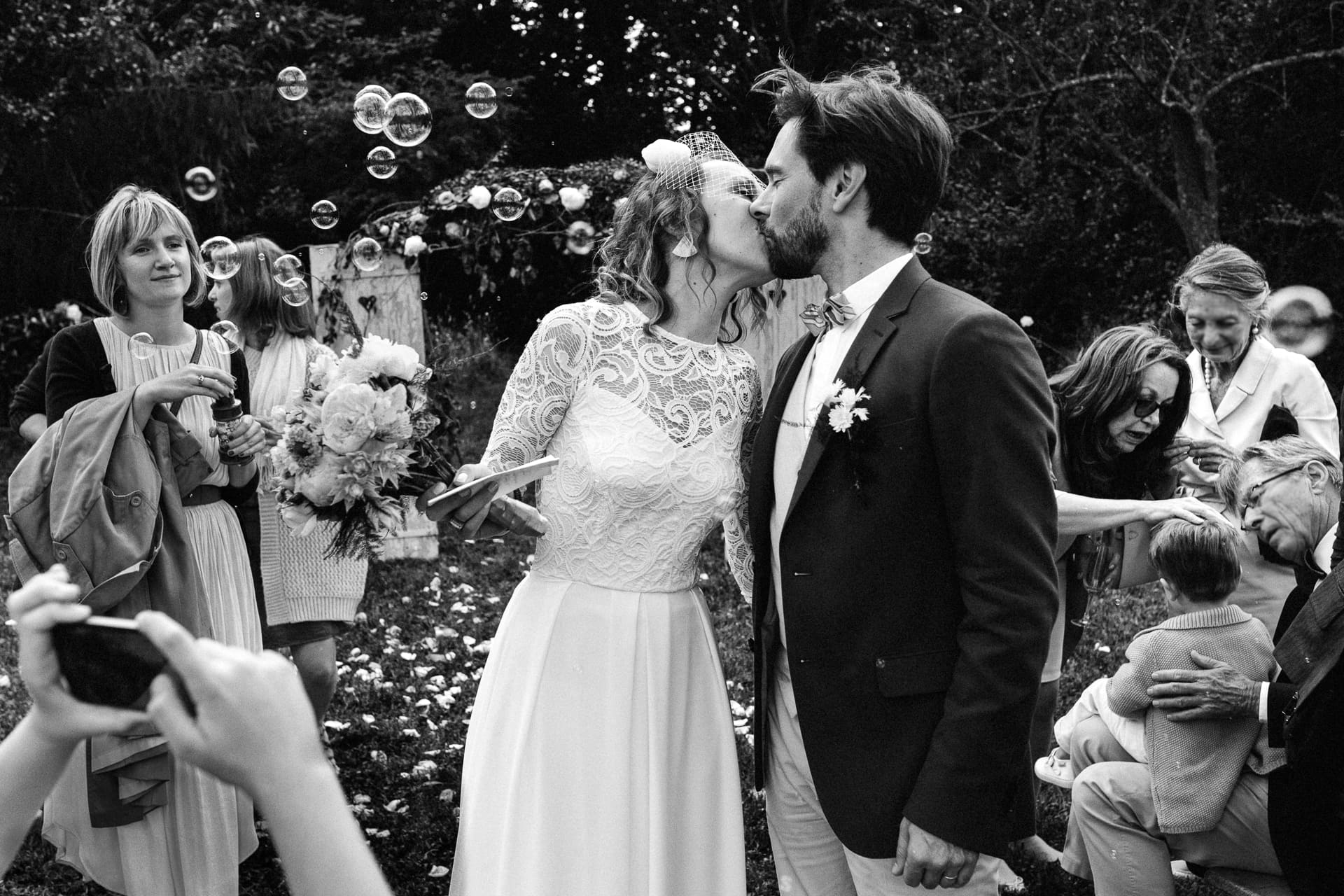 Ernestine-et-sa-famille-wedding and life photographer_2016-0010 ‣ Photographe de famille à l'approche documentaire pour vos évènements ou votre vie quotidienne, à Paris et dans toute la France Le baiser des mariés à la fin d'une cérémonie laïque en plein air par Ernestine et sa famille photographe de mariage à l'approche reportage