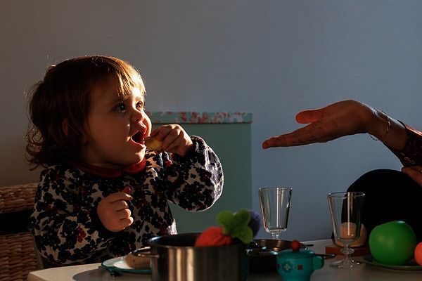 Petite fille qui mange une pomme. Reportage de vie quotidienne à domicile à Issy les Moulineaux.