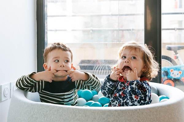 Les enfants font des grimaces dans la piscine à bulles. Reportage de vie quotidienne à domicile à Issy les Moulineaux.