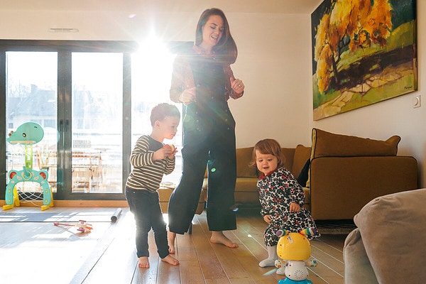 Maman danse dans le salon au soleil avec ses deux enfants Reportage de vie quotidienne à domicile à Issy les Moulineaux.